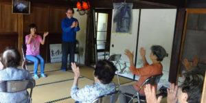介護施設でのレクリエーション活動。複数の入居者が参加し、スタッフが指導している様子